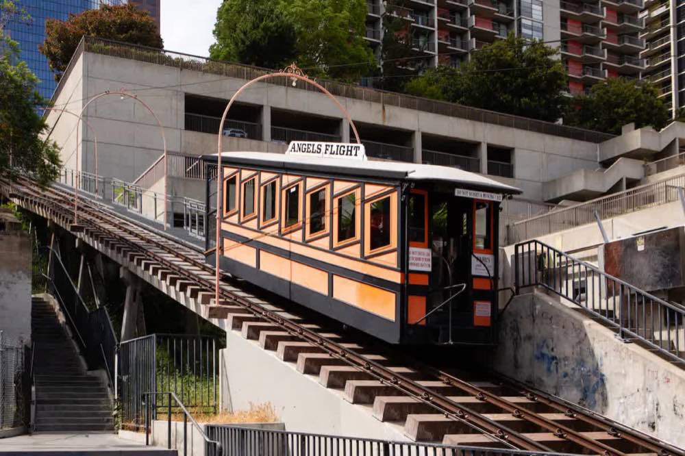 An orange Angels Flight funicular car climbs the Downtown Los Angeles incline.